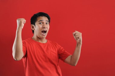 Asyalı genç adam mutlu ve heyecanlı Kazanan jestler.