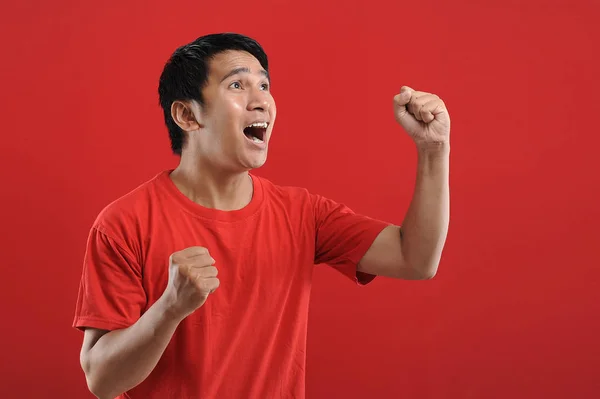 Молодой азиат счастлив и взволнован, выражая победный жест — стоковое фото