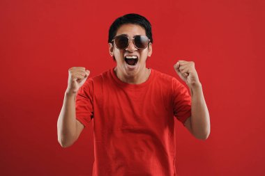 Asyalı genç adam mutlu ve heyecanlı Kazanan jestler. 