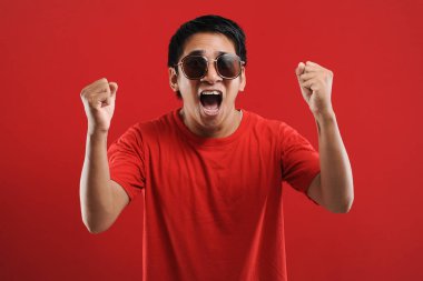 Asyalı genç adam mutlu ve heyecanlı Kazanan jestler.