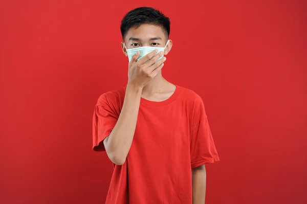 Koronavirüse karşı koruyucu maske takan Asyalı genç adamın portresi.