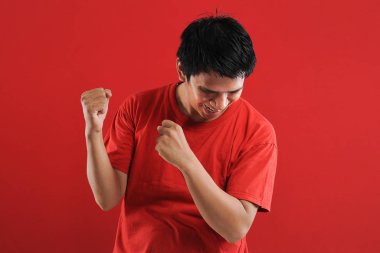 Asyalı genç adam mutlu ve heyecanlı Kazanan jestler. 