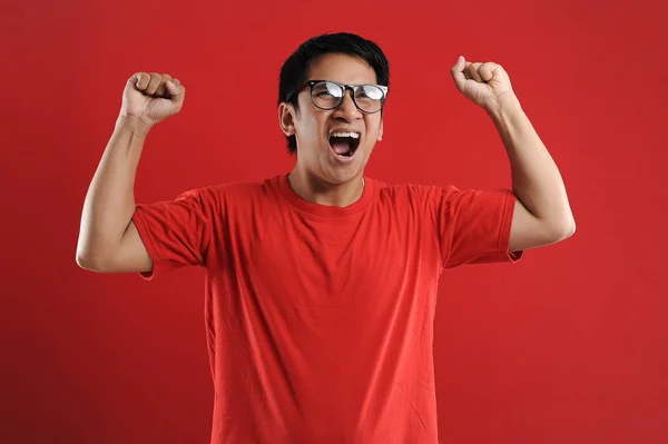 Young asian man happy and excited expressing winning gesture. — Stock Photo, Image