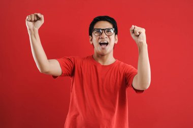 Asyalı genç adam mutlu ve heyecanlı Kazanan jestler. 