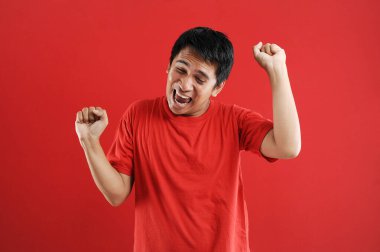 Asyalı genç adam mutlu ve heyecanlı Kazanan jestler. 