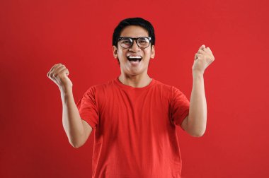 Asyalı genç adam mutlu ve heyecanlı Kazanan jestler. 