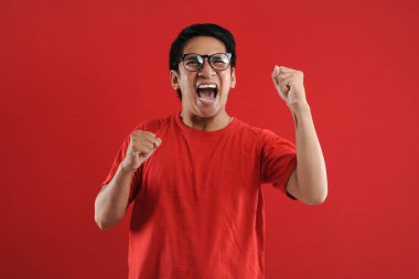 Asyalı genç adam mutlu ve heyecanlı Kazanan jestler. 
