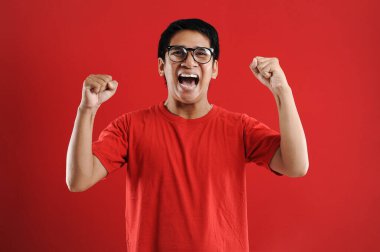 Asyalı genç adam mutlu ve heyecanlı Kazanan jestler. 