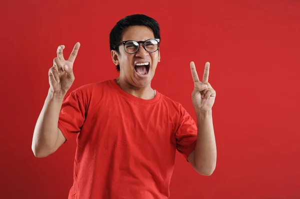 Young asian man happy and excited expressing winning gesture. — Stock Photo, Image