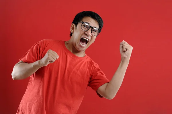 Young asian man happy and excited expressing winning gesture. Su — Stock Photo, Image