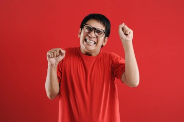 Genç Asyalı adam mutlu ve heyecanlı bir şekilde galibiyet jesti yaptı. Su