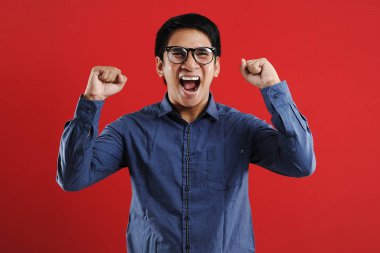 Genç Asyalı adam mutlu ve heyecanlı bir şekilde galibiyet jesti yaptı. Su