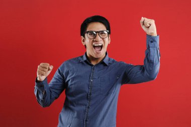 Genç Asyalı adam mutlu ve heyecanlı bir şekilde galibiyet jesti yaptı. Su