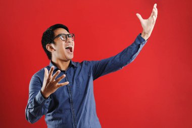 Genç Asyalı adam mutlu ve heyecanlı bir şekilde galibiyet jesti yaptı. Su