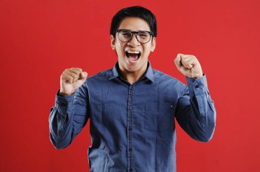 Asyalı genç adam mutlu ve heyecanlı Kazanan jestler.