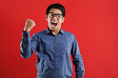 Asyalı genç adam mutlu ve heyecanlı Kazanan jestler