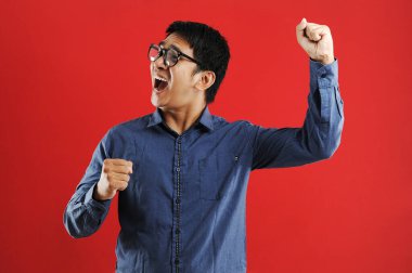 Asyalı genç adam mutlu ve heyecanlı Kazanan jestler.