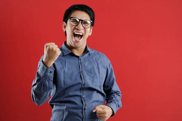 Asyalı genç adam mutlu ve heyecanlı Kazanan jestler.