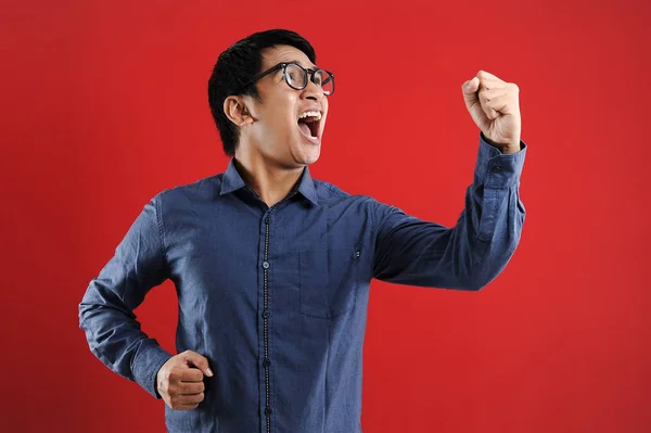Joven asiático hombre feliz y emocionado expresando el gesto ganador . — Foto de Stock