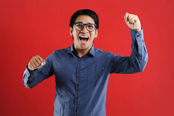 Young asian man happy and excited expressing winning gesture. — Stock Photo, Image