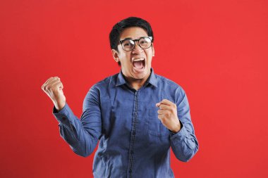 Asyalı genç adam mutlu ve heyecanlı Kazanan jestler.