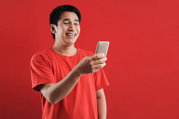 Glad asiatisk man läser ny text på mobilen — Stockfoto