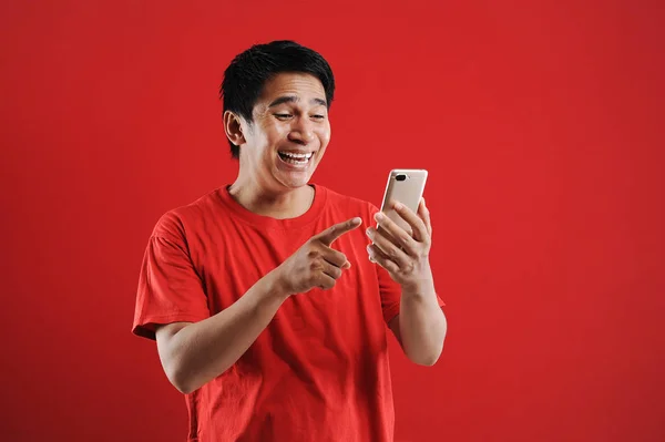 Glad asiatisk man läser ny text på mobilen — Stockfoto