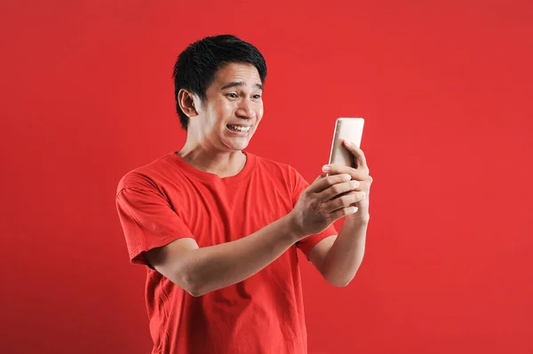Feliz hombre asiático leyendo nuevo texto en el móvil —  Fotos de Stock