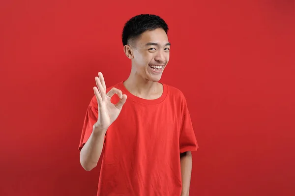 Young Asian Man Smiling Sign Happy Asian Man Red Background — Stock Photo, Image