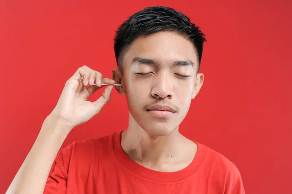 Young Asian Man Cleans His Ear Cotton Bud Isolated Red — Stock Photo, Image
