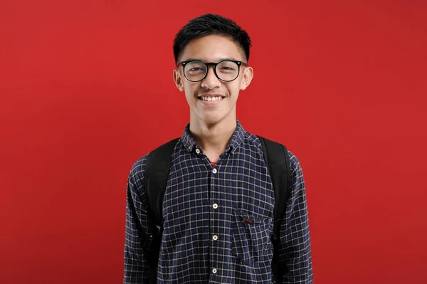 Молодий Азіатський Студент Усміхається Фотоапараті Окулярами Ізольованими Червоному Фоні — стокове фото