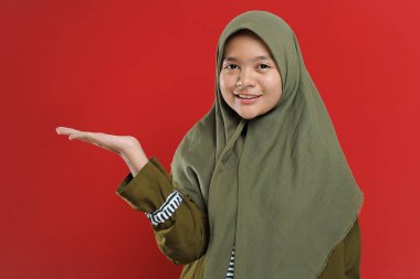 Genç, güzel Müslüman kadın boş kopya alanı gösteriyor. Hoş geldin jesti ile hoş geldin genç Müslüman. Müslüman kadınlar bir şey sunuyor.