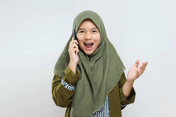 在拉马丹 快乐而兴奋的年轻穆斯林女性通过电话与她的朋友交谈 — 图库照片