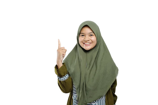 コピースペースで上を指しているヒジャーブの興奮したイスラム教徒の女の子 何かを提示するために上を指す若いイスラム教徒女性の肖像 — ストック写真