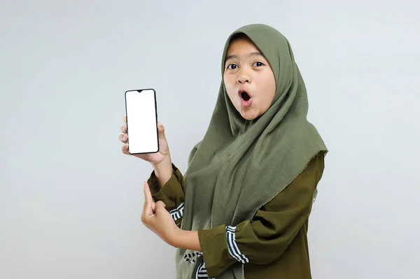 興奮した若いイスラム教徒の女性の肖像画白い画面で携帯電話を保持し 灰色に分離 — ストック写真