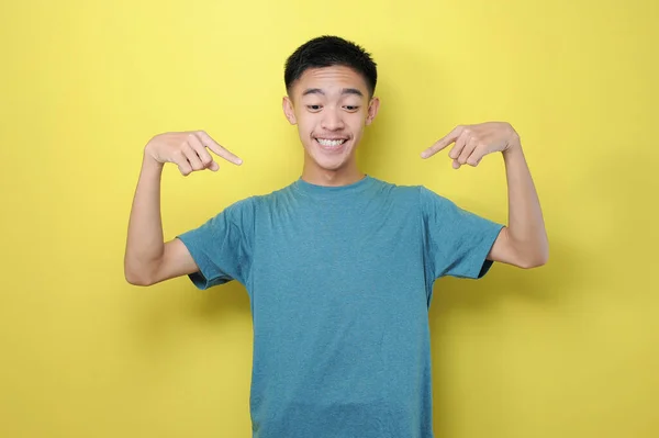 肖像画は黄色の背景に魅力的な若いアジアの男オープン口指数指を指して驚いて 新製品を宣伝したり 価格の概念の低下を示す — ストック写真