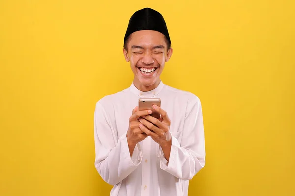 Jovem Asiático Muçulmano Homem Ler Mensagens Engraçadas Smartphone Isolado Fundo — Fotografia de Stock