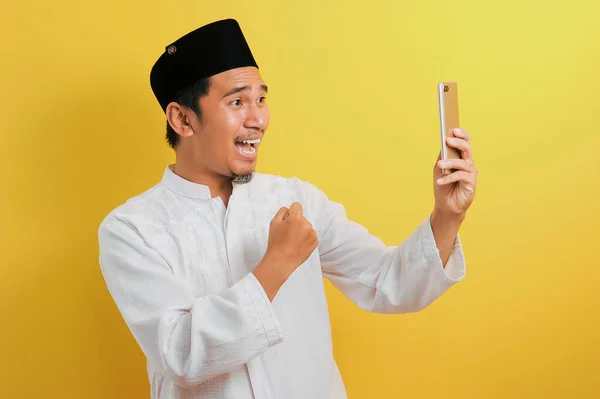 成功の肖像若いアジアのイスラム教徒の男は 黄色の背景に隔離された勝利ジェスチャーで幸せ — ストック写真