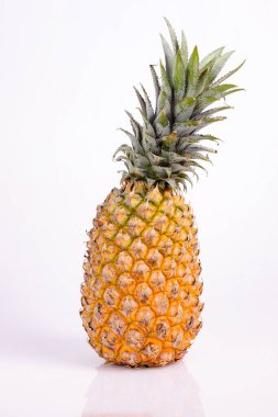 Tatlı ve taze ananas meyvesi, sarı arka planda izole edilmiş.