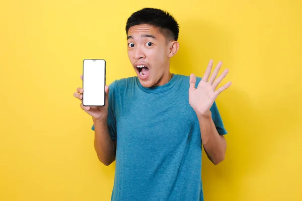 Genç Asyalı bir genç elinde cep telefonu tutarak kazanıyor Happy, kırmızı arka planda izole edilmiş özel bir hediye alıyor.