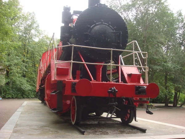 Old steam locomotive of the USSR museum exhibit. Old Russian locomotive. Steam locomotive with red wheels. Retro locomotive on rails.