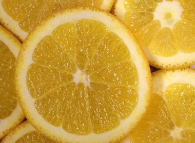 Taze sulu portakal. Dilimlenmiş portakal yığınıyla yapılmış arka plan.