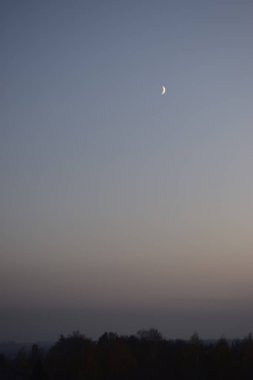 Yarım ay ve güzel gün batımı. Şehrin üzerinde gün batımı. Karanlık gökyüzünde ışık. Dramatik doğa geçmişi