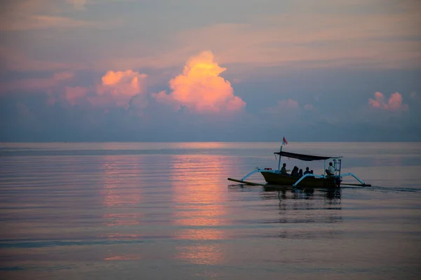 Bateau balinais avec des touristes pendant les couleurs du coucher du soleil sur le calme s — Photo