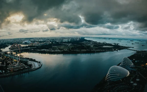 SINGAPORE - 2 DICEMBRE 2018: Vista panoramica notturna sulla baia di Marina dal tetto del Marina Bay Sands Hotel, con molte navi e navi ancorate in attesa di accesso allo scarico — Foto Stock