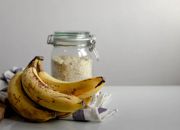 Över Havre Glasburk Med Bananer Och Blå Och Vit Duk Royaltyfria Stockbilder