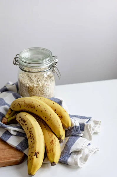 Över Havre Glasburk Med Bananer Och Blå Och Vit Duk Stockfoto