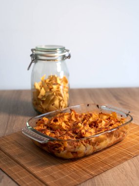 Bambu hasırının üzerinde vejetaryen bolonez bulunan rendelenmiş tagliatelle kristal tepsisinin ve kopya alanı ve beyaz arkaplanı olan ahşap bir masanın ön görüntüsünü kapat.