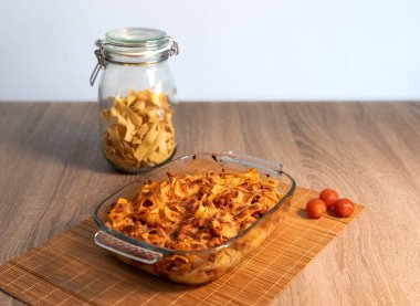 Bambu hasırının üzerinde vejetaryen bolonez bulunan rendelenmiş tagliatelle kristal tepsisinin ve kopya alanı ve beyaz arkaplanı olan ahşap bir masanın ön görüntüsünü kapat.