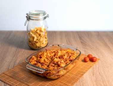 Bambu hasırının üzerinde vejetaryen bolonez bulunan rendelenmiş tagliatelle kristal tepsisinin ve kopya alanı ve beyaz arkaplanı olan ahşap bir masanın ön görüntüsünü kapat.